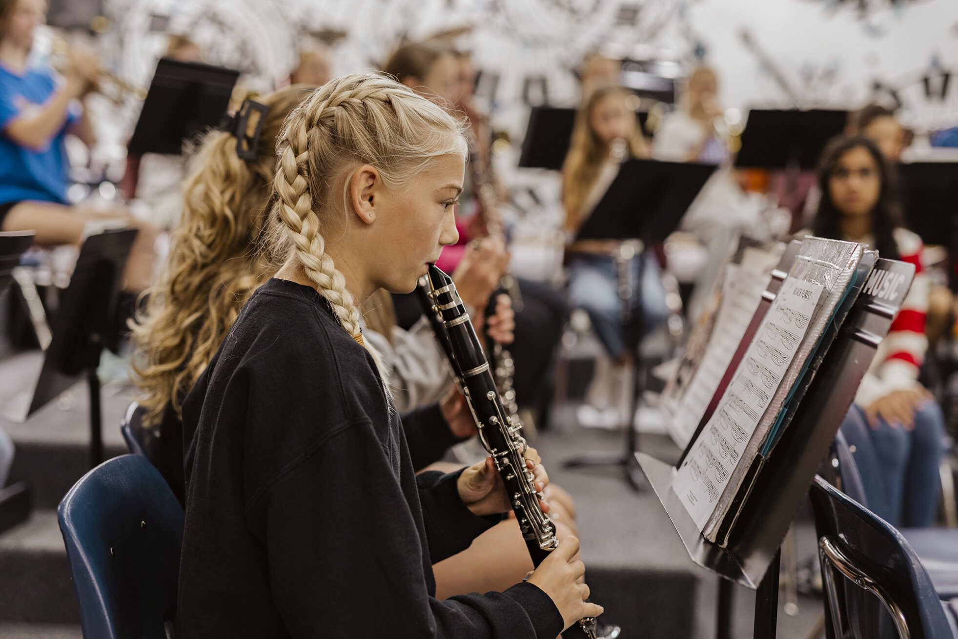 A female ACS middle school student plays clarinet in band class.